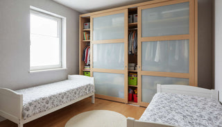 Shared bedroom with two beds and a wardrobe divided into hanging and shelving sections