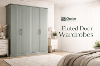 A bedroom with a large green fluted door wardrobe, two white nightstands with drawers, decorative items, a bed with beige bedding, and the text Fluted Door Wardrobes on the wall.