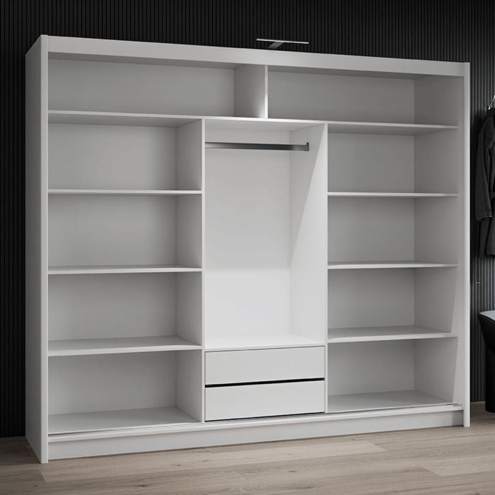 Open view of a white sliding wardrobe showing multiple shelves, a hanging rail, and two drawers.