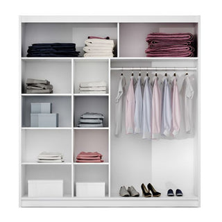 White sliding wardrobe interior view with shelves, hanging rails, and shoes on the bottom shelf.