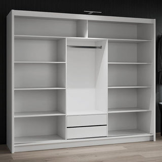 Open white 3-door sliding wardrobe interior with shelves, hanging rail, and two drawers