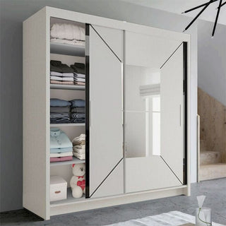 The BARTHOLOMEW 2 Door Mirrored Wardrobe White 120cm features high-gloss sliding doors; one is open to display shelves with folded clothes, towels, blankets, a stuffed animal, and two storage boxes inside.