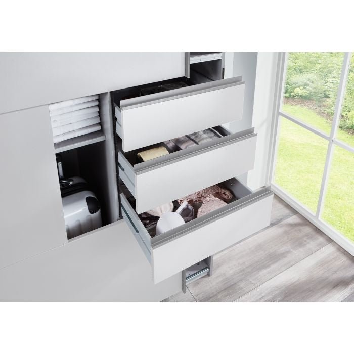 White 3-door sliding wardrobe with open drawers showing household items and a mirrored door