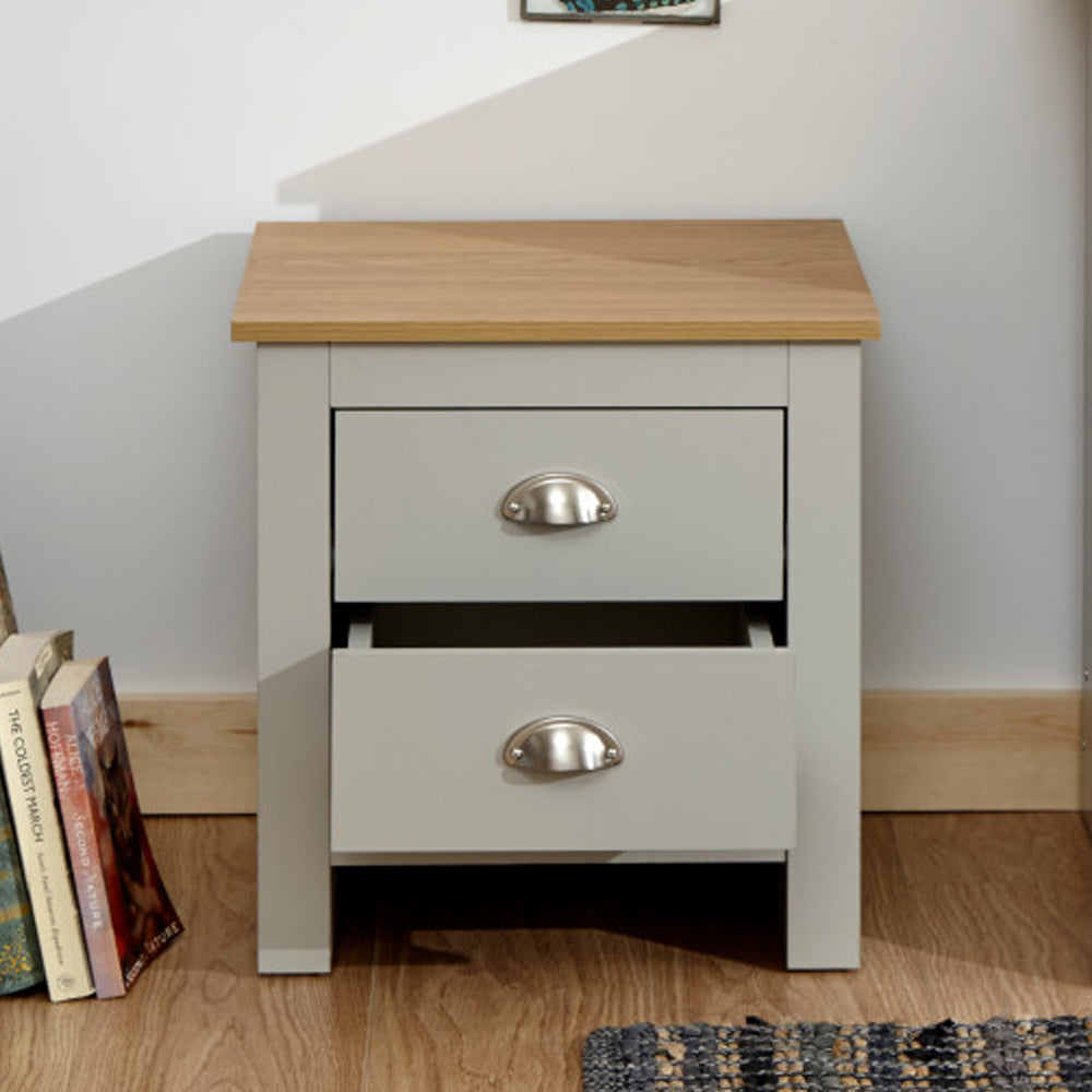 Grey and oak bedside cabinet with two drawers, featuring a contrasting oak top and metal cup handles. Bottom drawer is partially open.