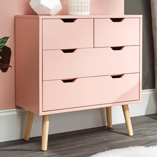 Coral pink wooden chest of 4 drawers with angled legs and cutout handles.