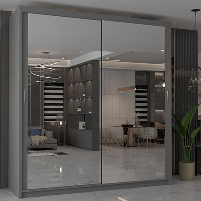 The CHOICEWARDROBE CHICAGO II 2 Door Sliding Door Wardrobe with grey mirrored doors (203 cm) adds contemporary style and practical storage to any modern bedroom, reflecting a neutral-toned living space with chic decor and a tall potted plant.