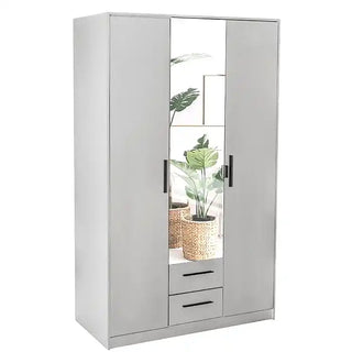 The WINSTEAD 3 Door Mirrored Wardrobe in Matt White (120cm) features a mirrored central panel, two doors, and bottom drawers—reflecting potted plants and artwork for an elegant modern bedroom look.