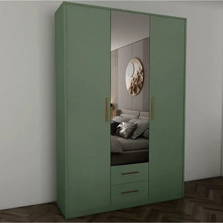 The WINSTEAD 3 Door Mirrored Wardrobe in Dark Green (135cm) features gold handles and a central mirror that reflects the bed, round wall art, and part of the bedroom, standing against a white wall on a wooden floor.