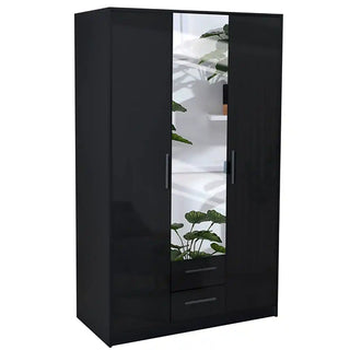 The WINSTEAD 3 Door Mirrored Wardrobe in black (135cm) offers ample storage and two drawers. Its central high gloss mirror reflects lush green plants and white shelves in the background.