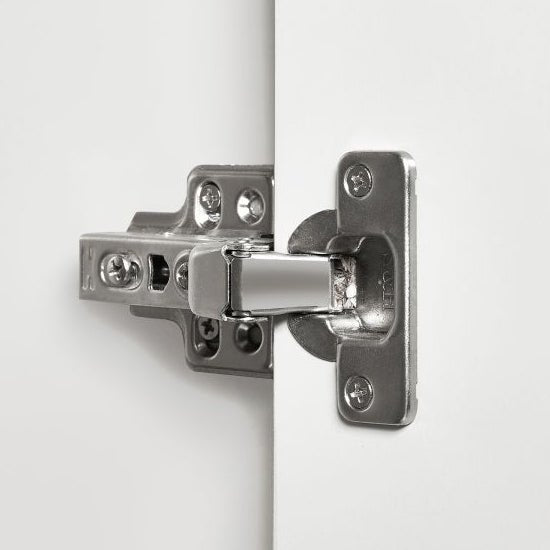Close-up of a silver hinge on a two-door wardrobe with white and oak finish.