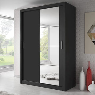 The CHOICEWARDROBE Allen Sliding Door Wardrobe in matt black, featuring a full-length mirror, adds elegance and practical storage to a modern room with white floors, large windows, and decorative vases.
