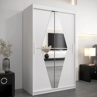 The CHOICEWARDROBE Beloit Sliding Door Wardrobe, 120cm wide with white finish and mirrored doors, features a geometric design in a modern UK bedroom. A black nightstand with a lamp and vase sits beside it, while the TV reflects in the mirrors.