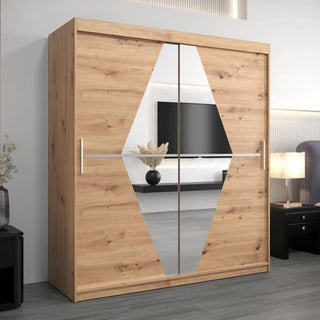 The Beloit Mirrored Wardrobe 2 Sliding Doors 180cm in Artisan Oak stands in a modern bedroom, centered by a large geometric mirror with a TV, vase, and lamp seen in the background.