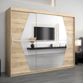 The Beloit Mirrored Wardrobe 3 Sliding Doors 250cm in Sonoma Oak features geometric mirrored panels that reflect a wall-mounted TV, decorative shelf, and elements of a modern bedroom interior.