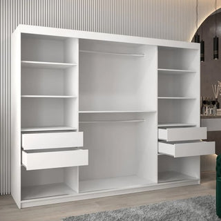The Beloit Mirrored Wardrobe 3 Sliding Doors 250cm in White stands against a textured wall and light wood floor, featuring open shelving, two hanging rods, and four drawers. A green seat and grey rug complete the stylish bedroom setup.