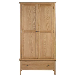 The Callia Wooden Wardrobe With 2 Doors 1 Drawer In Natural is crafted from solid oak, featuring paneled doors and a bottom drawer with metal knobs—ideal for adding stylish storage to your bedroom.