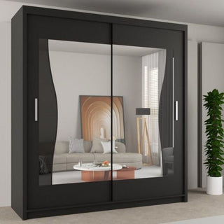 The CHOICEWARDROBE 180cm Black Sliding Door Wardrobe with wave mirrored glass front reflects a beige sofa, round coffee table, wall art, large windows with blinds, and a green potted plant in a modern room.