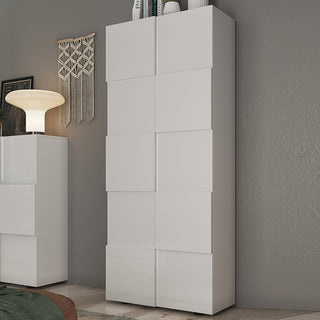 The CHOICEWARDROBE Aleta 2 Door Wardrobe in white high gloss stands tall against a gray wall, featuring modern shelves and a hanging rail. A white lamp, artwork, and another similar cabinet are also partially visible nearby.