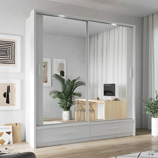 A CHOICEWARDROBE Aliso LED Mirrored Wardrobe with 2 sliding doors, matt white finish, full-length mirror panels, soft-close system, and LED lighting stands in a bright bedroom, reflecting a desk with a computer, plant, curtains, and wall art.