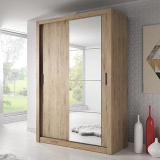 A CHOICEWARDROBE Aliso Shetland Oak Sliding Door Wardrobe with Mirror stands in a bright, modern room with white walls, decorative vases, a rug, geometric wall art, and large windows revealing greenery outside.
