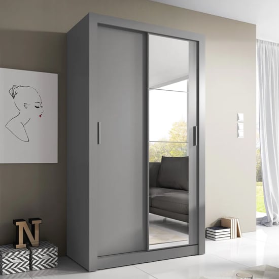 Matt grey sliding wardrobe with one mirrored door in a modern bedroom.