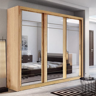A modern bedroom showcases the CHOICEWARDROBE Allen 250cm Shetland Oak Sliding Wardrobe with 3 full mirror doors, offering premium spacious storage. The room also features a bed, nightstands, a lamp, and striped rugs on the floor.