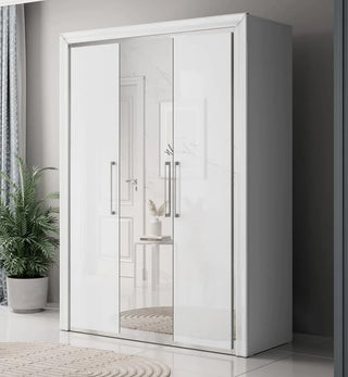 The CHOICEWARDROBE Allen 3 Door Mirrored Wardrobe in white high gloss brings modern storage to a bright room. Metal handles and glossy surfaces reflect light, while shelves and a hanging rail keep your bedroom organized. A potted plant sits nearby.