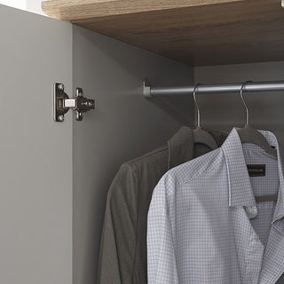 A close-up of two shirts hanging on a metal rod inside the CHOICEWARDROBE Alverton 3 Door Wardrobe in grey with oak effect top and drawers, with the partially open door showing its hinge and shelves above.