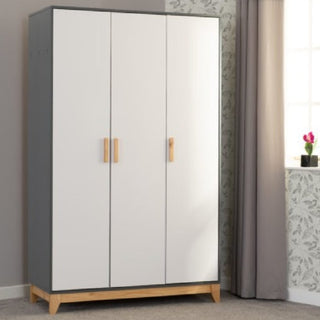 The CHOICEWARDROBE Arthur 3 Door Wooden Wardrobe in a modern Scandi white & grey finish with oak handles stands by a wall near a window with grey curtains and a small potted plant on the sill.