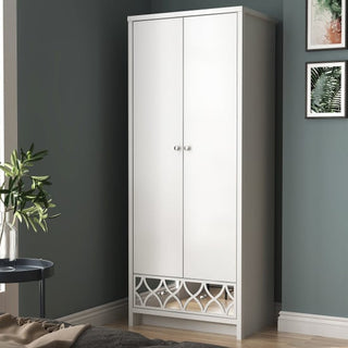 The CHOICEWARDROBE Asmara 2 Door Wardrobe in white gloss with a mirrored decorative panel stands against a dark wall near a bed, a side table with a plant, and framed artwork, adding elegant modern storage to the bedroom.