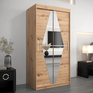 The CHOICEWARDROBE Beloit 100cm Oak Sliding Wardrobe with diamond-mirror doors stands by a white wall, paired with a black nightstand holding a vase and lamp. A TV is mounted on the opposite wall.
