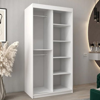 The CHOICEWARDROBE Beloit 2 Door Sliding Mirrored Wardrobe in white matte stands against a striped wall, featuring a stylish geometric mirror design, hanging rail, and internal shelving for space-saving storage in a modern room.