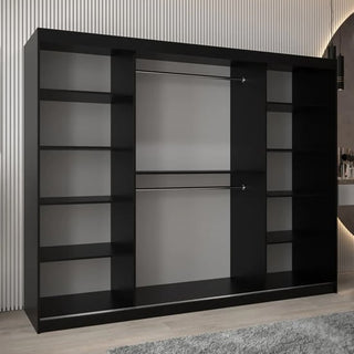 The CHOICEWARDROBE Beloit 3 Door Sliding Mirrored Wardrobe (250 cm, Black with Geometric White Panels) features multiple side shelves and two central hanging rails, seen on a light wood floor beside a gray rug in a modern room.