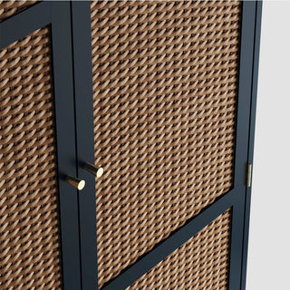 A close-up of the CHOICEWARDROBE Bordeaux 2 Door Rattan Wooden Wardrobe, showing its woven rattan panel in a navy blue frame with two gold cylindrical handles and a visible gold hinge, blending boho-modern style and practical design.