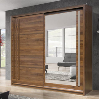 The CHOICEWARDROBE Brentwood 200cm Sliding Wardrobe in walnut, featuring 2 doors with a full-length mirror, is showcased in a modern living room with a gray sofa and large windows.