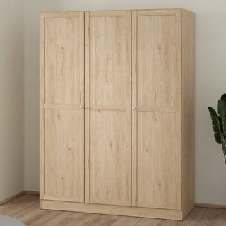 The CHOICEWARDROBE Burbank 147cm 3 Door Wooden Wardrobe in Hickory Oak finish stands in a corner with wood flooring, while a green plant on the right adds freshness to this stylish storage piece featuring hanging rail and shelving.