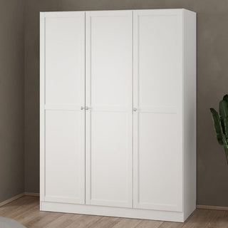 A CHOICEWARDROBE Burbank 3 Door Wooden Wardrobe in a white finish with a minimalist modern design, hanging rail, and shelves stands against a beige wall on a wooden floor. A green plant is partially visible on the right.