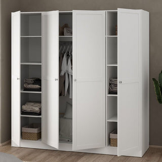 The CHOICEWARDROBE Burbank 4 Door Panelled Wooden Wardrobe in white shaker style stands open, showing folded clothes, baskets, and hanging shirts. It sits against a plain wall on a wooden floor with a green plant on the right.