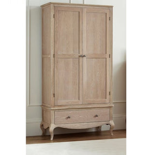 The CHOICEWARDROBE Caitlyn Wooden Wardrobe in an oak finish, with 2 paneled doors, a spacious bottom drawer, elegant curved legs, and antique metal handles, stands against a cream-colored wall.