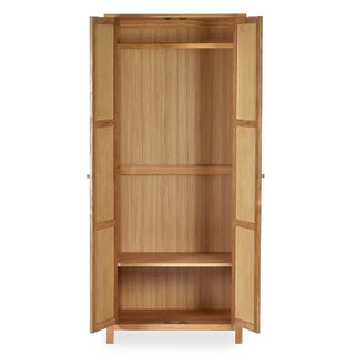 The CHOICEWARDROBE Calliope 80cm 2 Door Solid Wooden Wardrobe in a natural oak finish features ample bedroom storage with a hanging rail and shelf, combining simple style and functionality for any space.