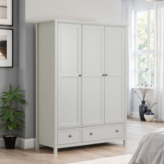 The CHOICEWARDROBE Cheshire 3 Door 3 Drawer Wardrobe in a soft grey Shaker design with brushed metal handles provides ample bedroom storage and style, perfect for bright rooms with light wood floors and modern accents.
