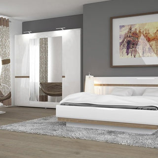 Cheya 218cm White & Truffle Oak 4 Door Mirrored Wardrobe styled in a contemporary bedroom with coordinated oak décor.