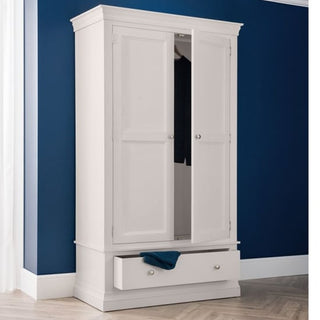 A CHOICEWARDROBE Chirk 2 Door 1 Drawer Wardrobe in light grey, with paneled doors and a classic country design, stands against a dark blue wall. Its bottom drawer is partially open to reveal a blue cloth—perfect for fans of French-inspired bedroom furniture.