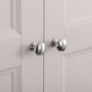 Close-up view of two silver metal knobs on white cabinet doors with a raised panel design, part of the CHOICEWARDROBE Chirk 2 Door 1 Drawer Wardrobe in a light grey finish with classic country styling.