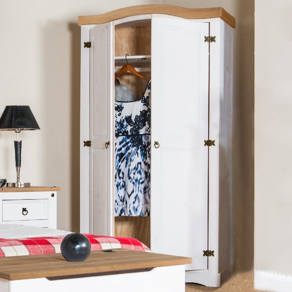 White & oak 2-door wardrobe with a dress inside, showing curved top and rustic hinges.