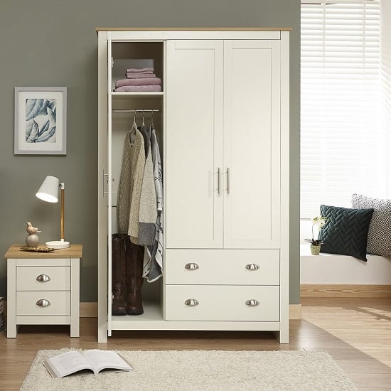 CHOICEWARDROBE Crick Cream & Oak 3-door wardrobe with 2 drawers, open with clothes and boots inside.