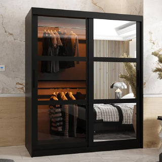 The CHOICEWARDROBE Danville 150cm Black Glass Mirrored Sliding Door Wardrobe features luxury panels, adjustable shelving, and hanging rails, displaying clothes on one side while reflecting a contemporary bedroom setting.