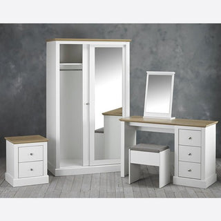 The CHOICEWARDROBE Darnell 2 Door Sliding Wardrobe in white, with a full-length mirror and double hanging rail, stands on a gray wood floor as part of a modern white bedroom set with wooden tops, nightstand, and dressing table.