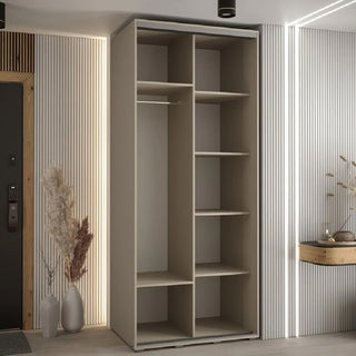 A CHOICEWARDROBE Delta 100cm 2 Door Sliding Wardrobe in a sleek cashmere finish with black trim stands against vertical white paneling, accompanied by decorative vases with dried plants and a small console table.
