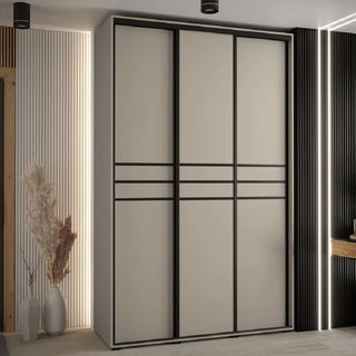 The CHOICEWARDROBE Delta 3 Door Sliding Wardrobe in Cashmere (150cm) with modern wooden design, black trim, and shelving storage stands in a minimalist room with vertical LED strip lighting and dried plants in vases.